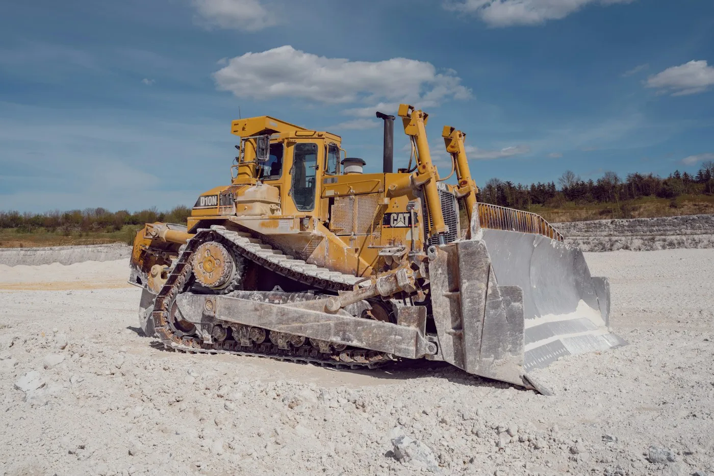 Bulldozer moving aggregate beneath a blue sky